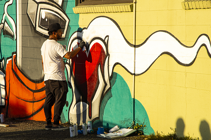 Street artist painting a wall.